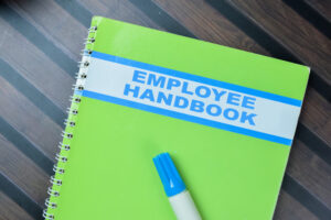 Concept of Employee Handbook write on book isolated on Wooden Table.